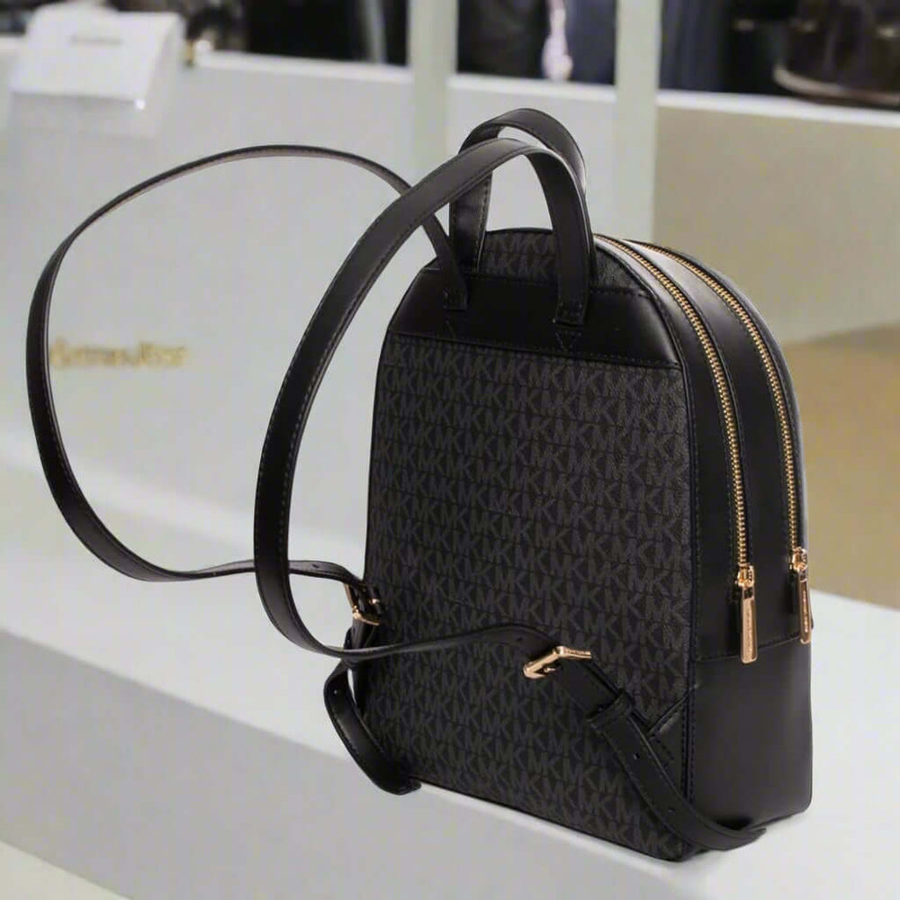 Black backpack with gold zippers on a white background
