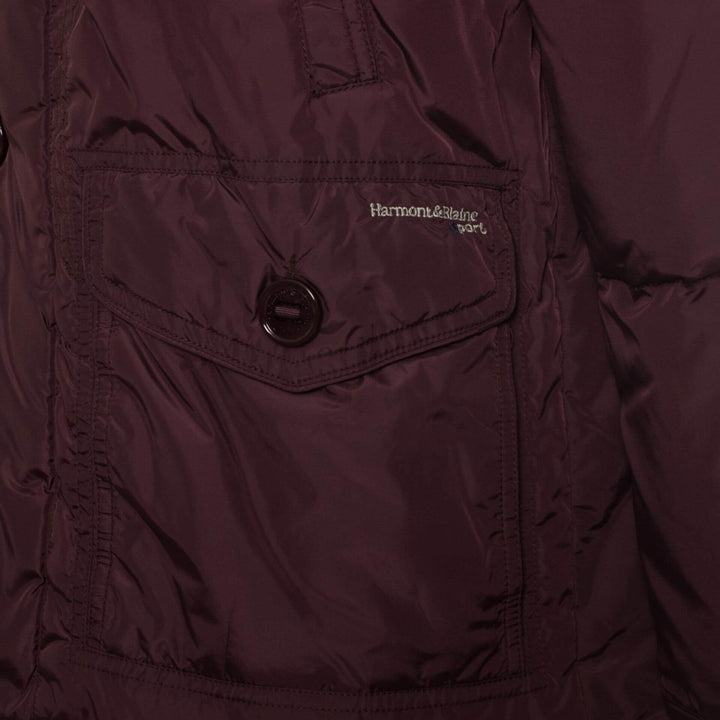 Close-up of a maroon jacket with a visible brand logo on a dark background