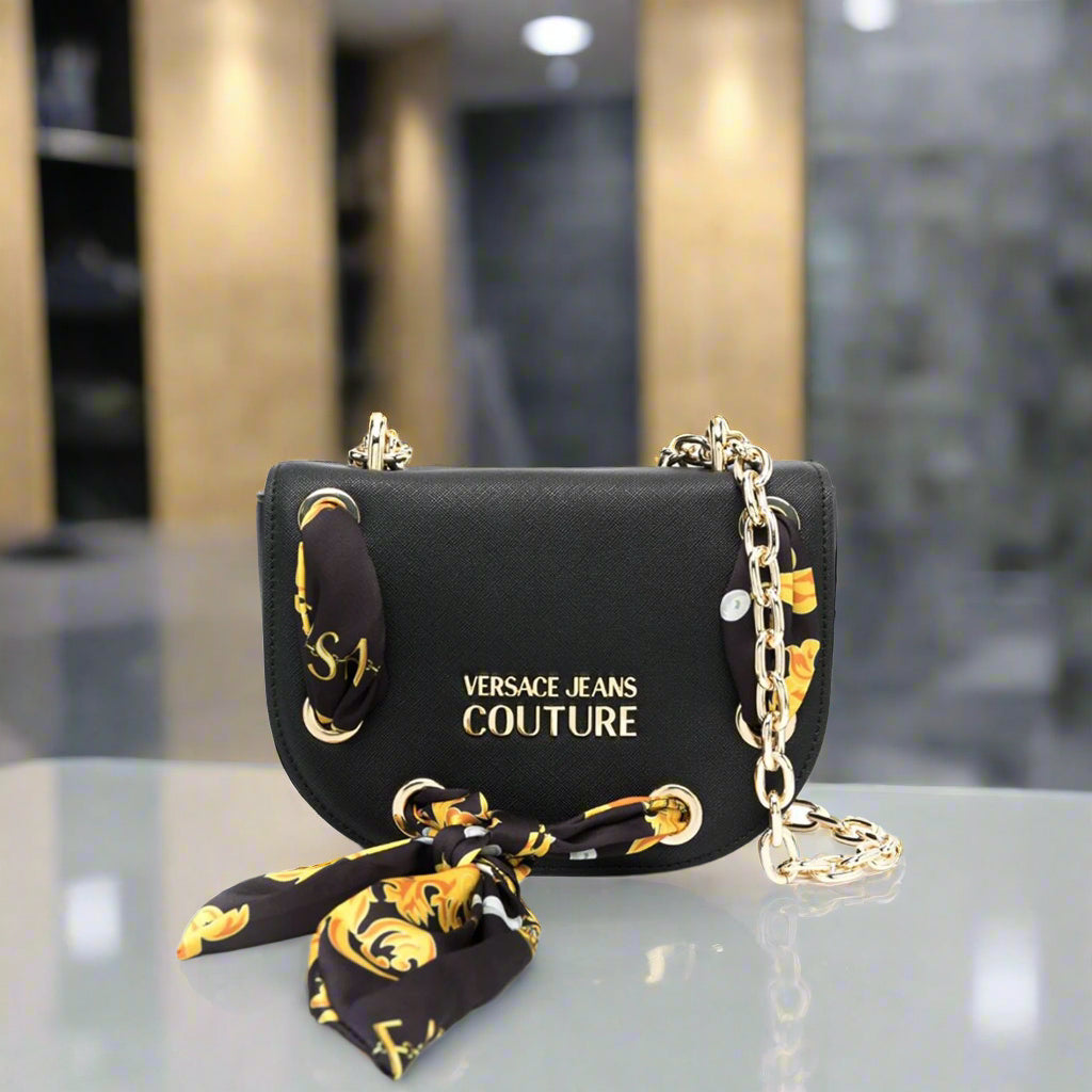 Versace Jeans Couture shoulder bag in black with gold emblem and decorative scarf, stylish synthetic leather crossbody handbag.