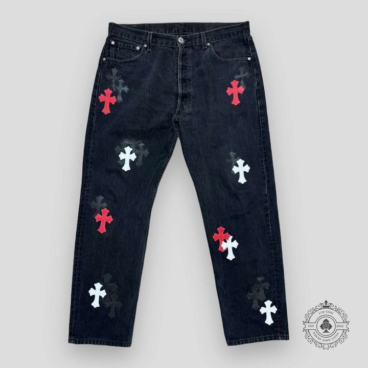 Black jeans with red and white cross patterns on a gray background