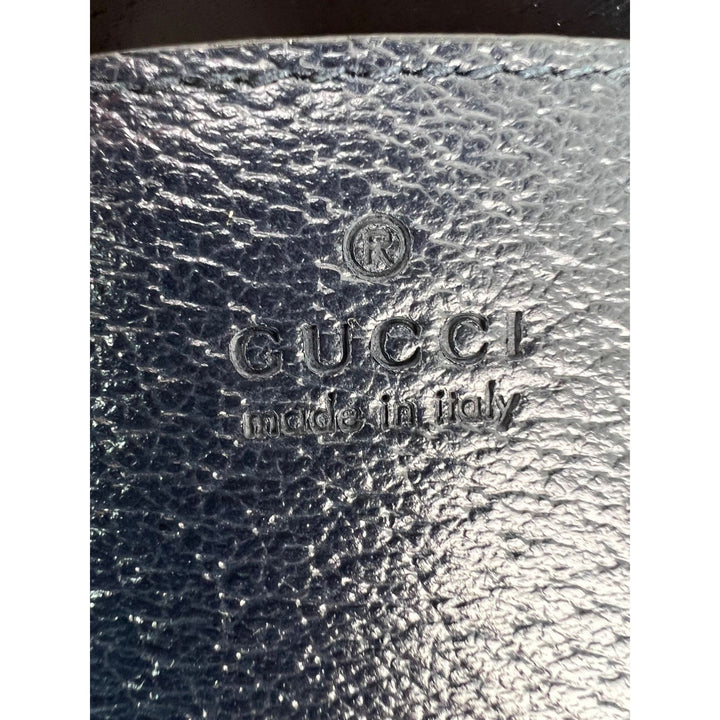 Close-up of the embossed Gucci logo on the GG Supreme Dollar Calfskin Web Small Padlock Navy Tote.