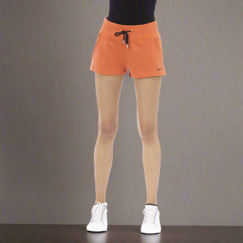 Person wearing orange shorts on a white background
