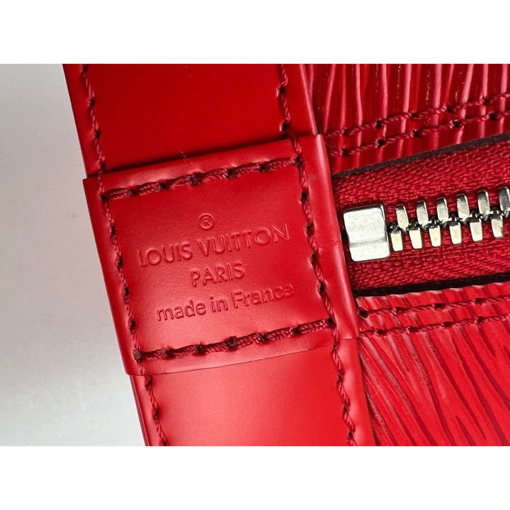 Close-up of a red Louis Vuitton wallet with visible branding and 'made in France' text.