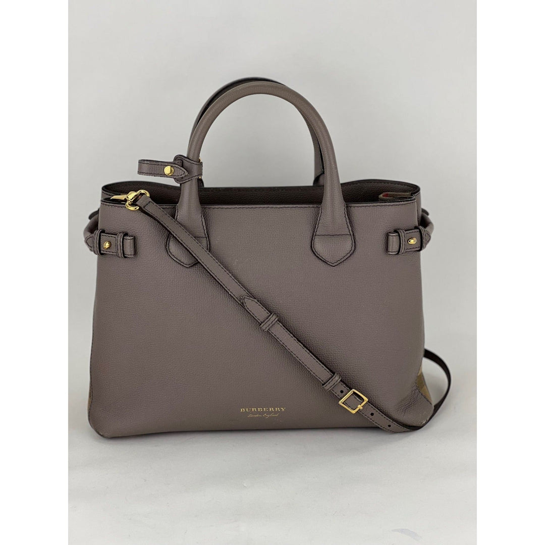 Gray handbag with a shoulder strap on a light gray background