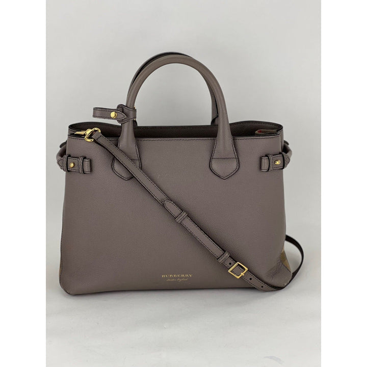 Gray handbag with a shoulder strap on a light gray background