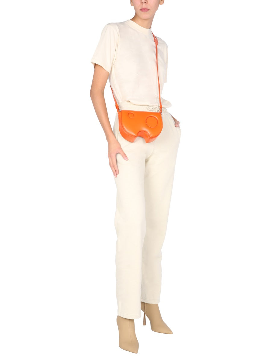 Person wearing a white outfit with an orange bag on a white background