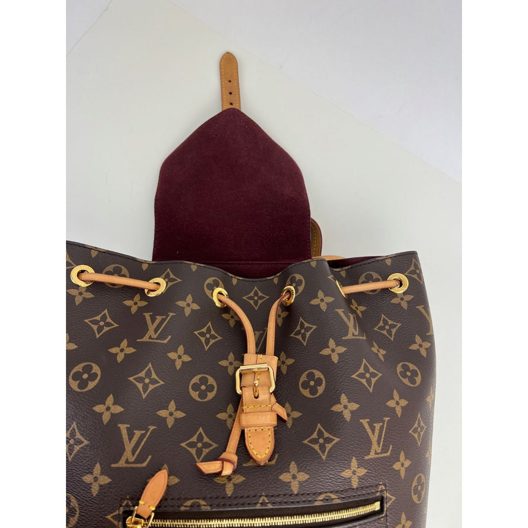 LOUIS VUITTON Montsouris NM Monogram Backpack showing the interior with burgundy microfiber lining and leather pull tab.