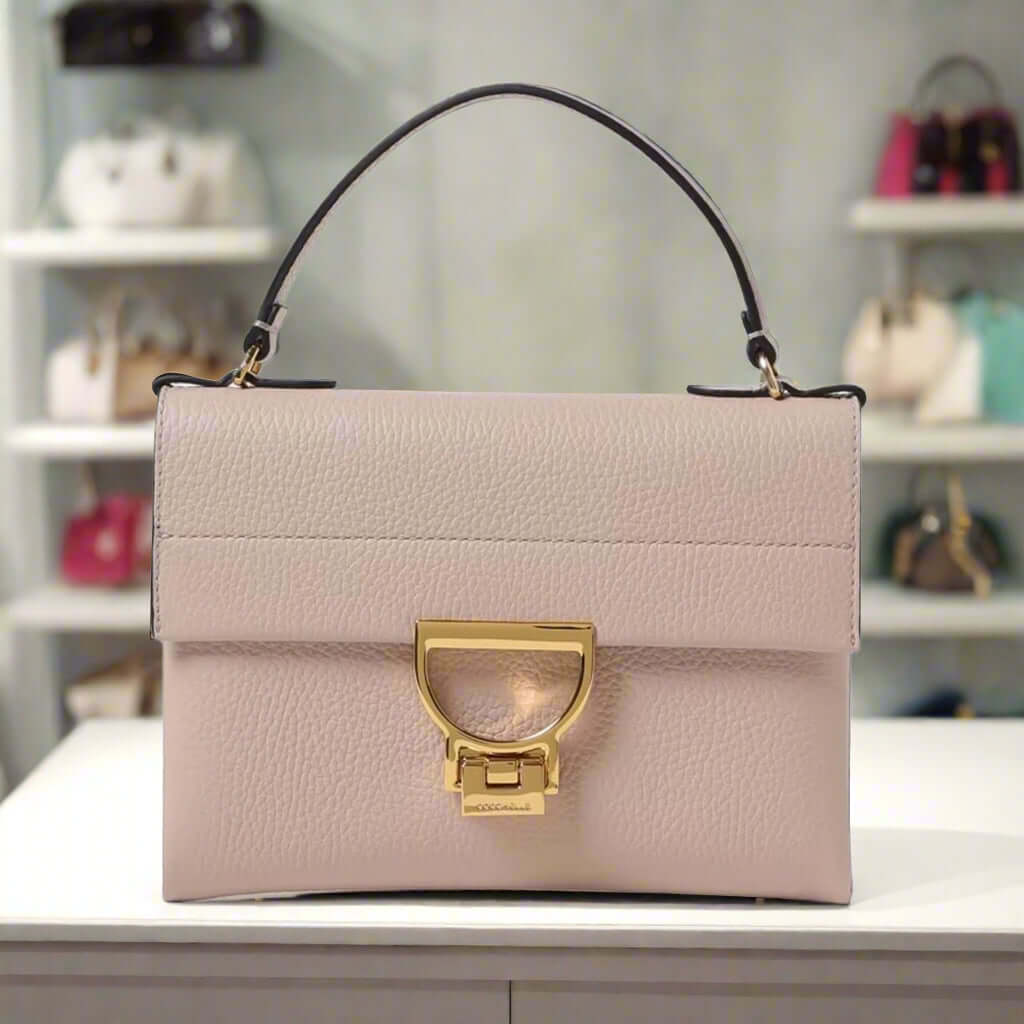 Beige handbag with a gold clasp on a white background