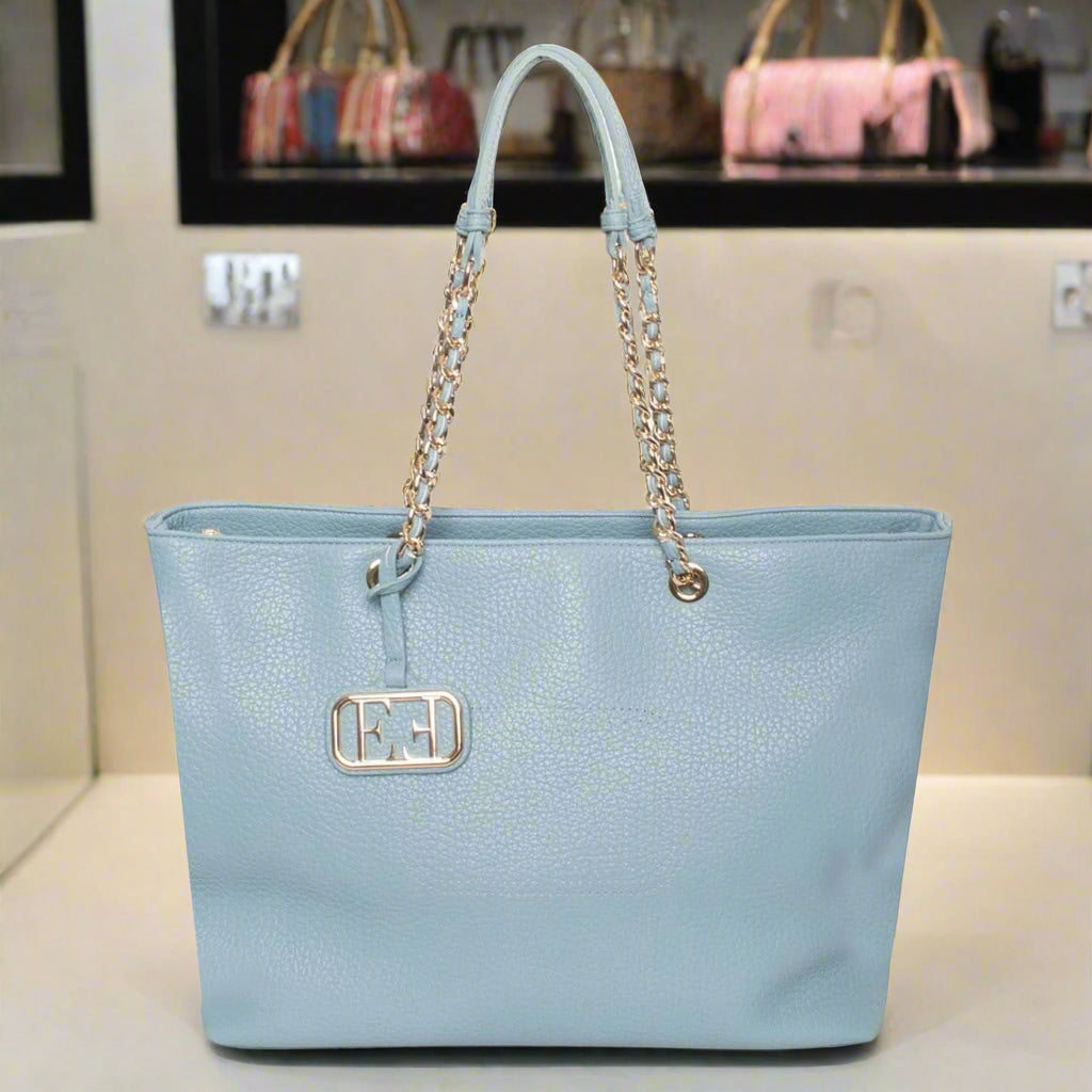 Light blue handbag with gold chain handle on a white background