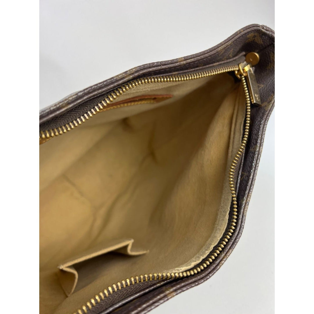 Interior view of LOUIS VUITTON Looping GM Monogram Shoulder Bag showcasing gold zipper and lined compartment for luxury bags.
