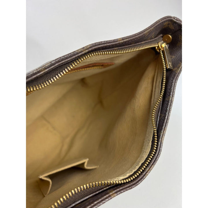 Interior view of LOUIS VUITTON Looping GM Monogram Shoulder Bag showcasing gold zipper and lined compartment for luxury bags.