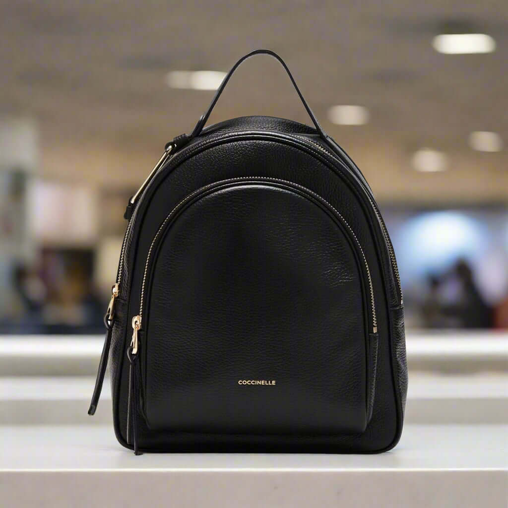 Black backpack with gold zippers on a white background