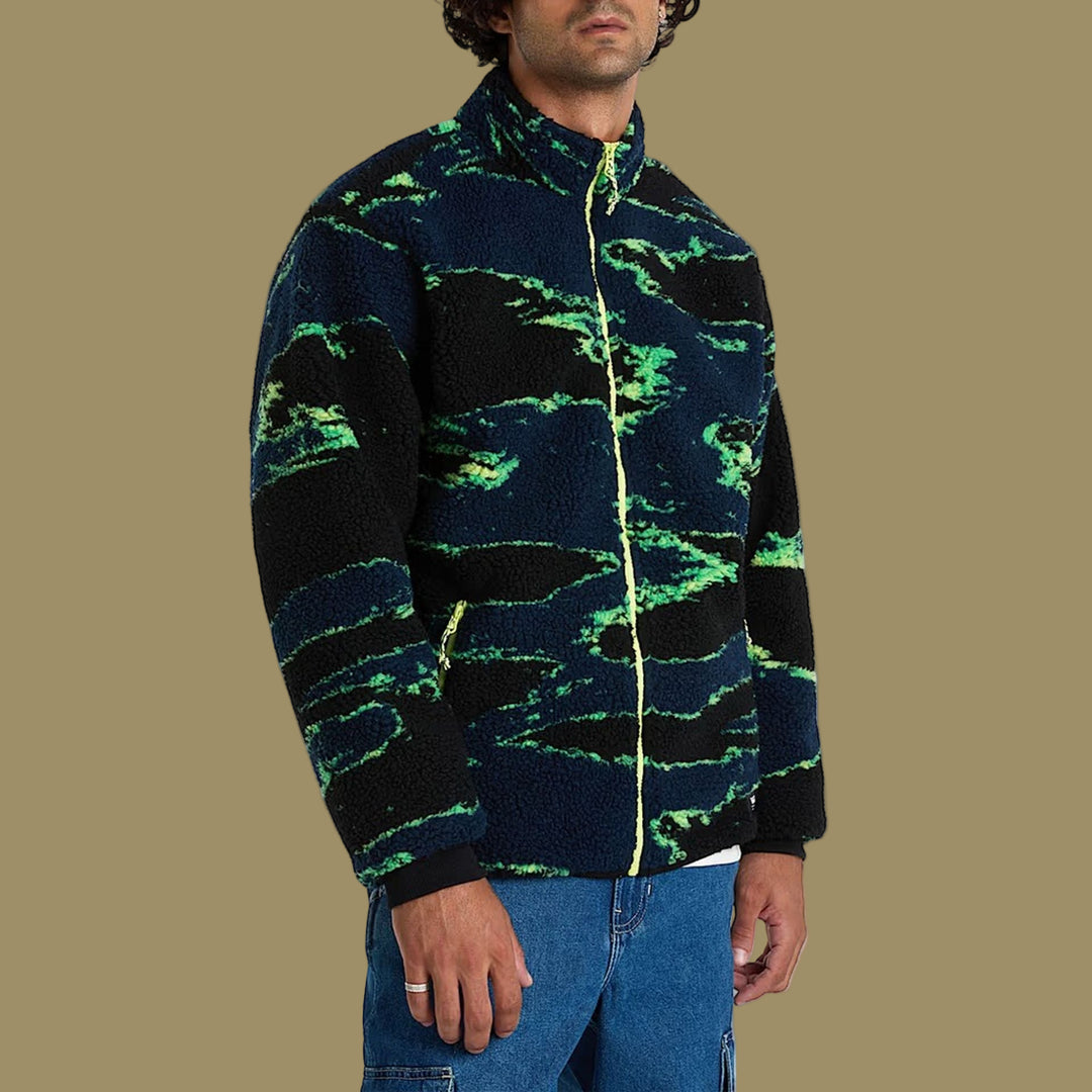 Person wearing a black and green patterned jacket on a white background
