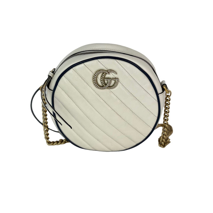 White round handbag with gold chain strap on a white background