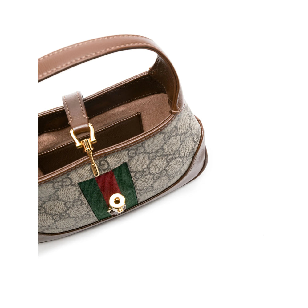 Close-up of a Gucci handbag with a signature green and red stripe on a white background