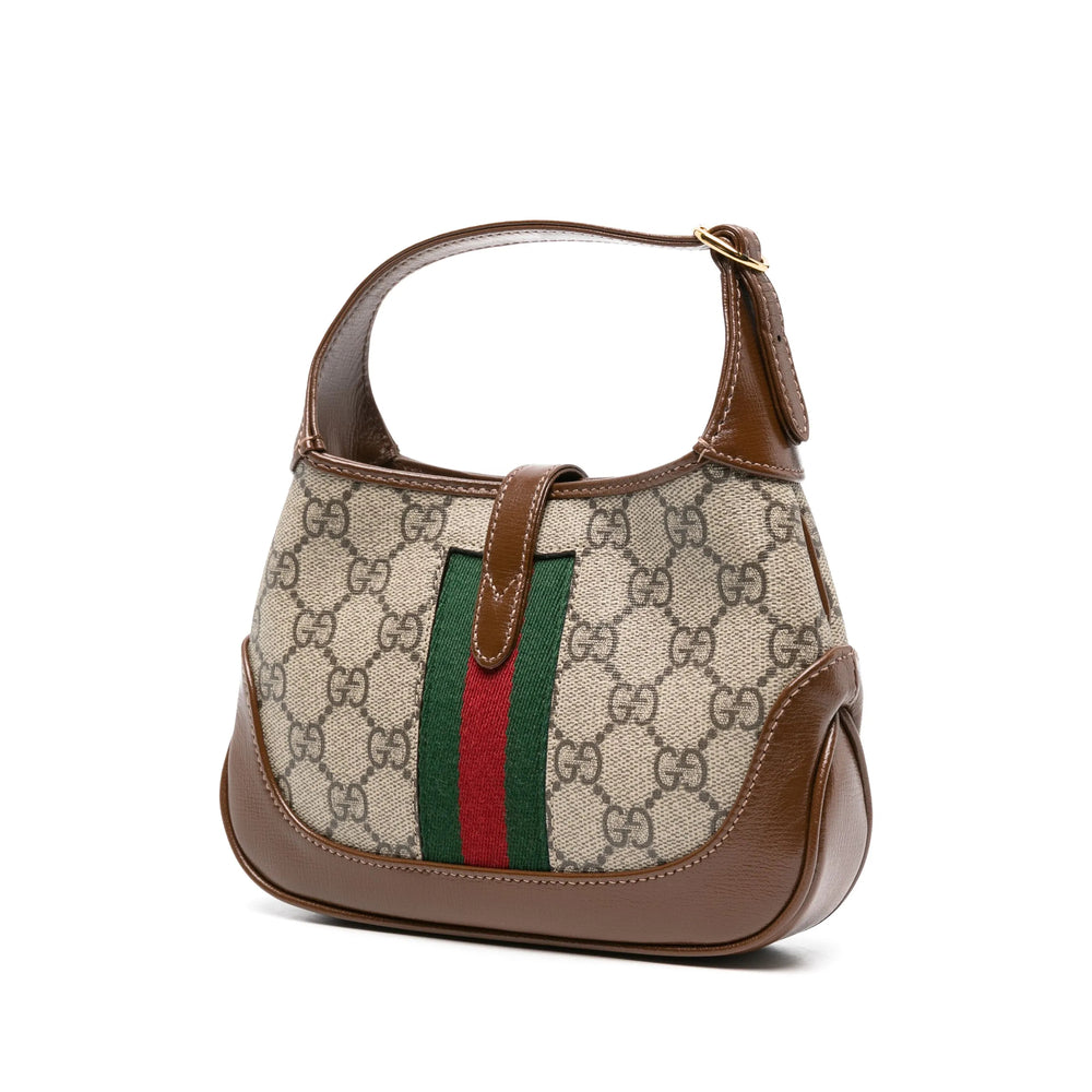 Designer handbag with patterned fabric and brown leather accents on a white background