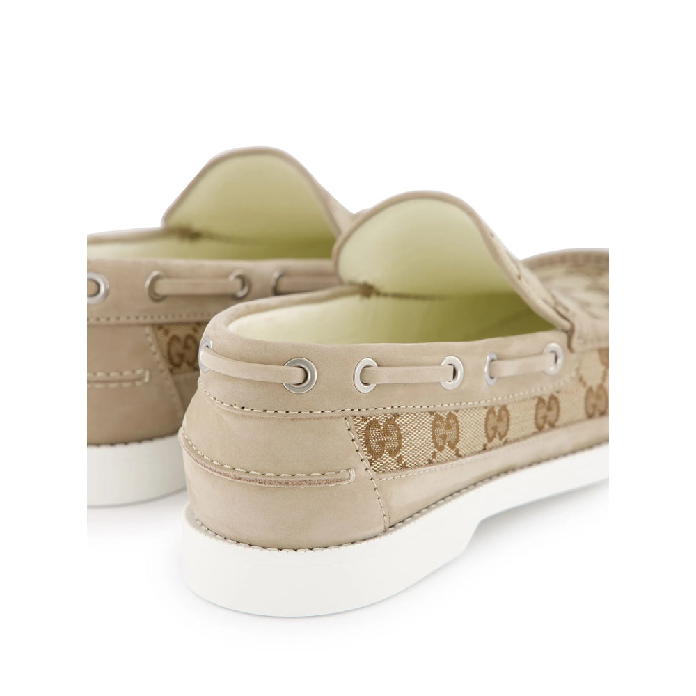Beige boat shoes with brand logo on a white background