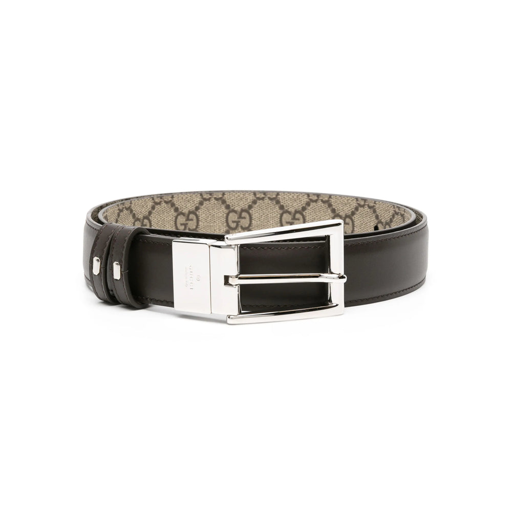 Black and beige Gucci belt with silver buckle on a white background