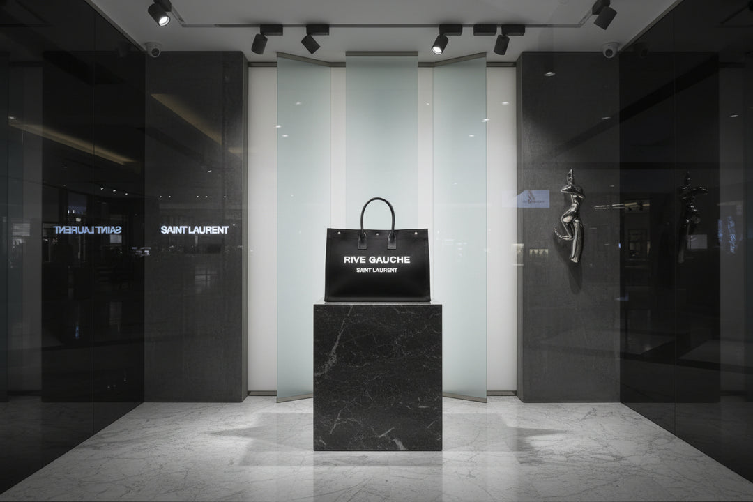 Black tote bag with 'Rive Gauche Saint Laurent' text on a white background