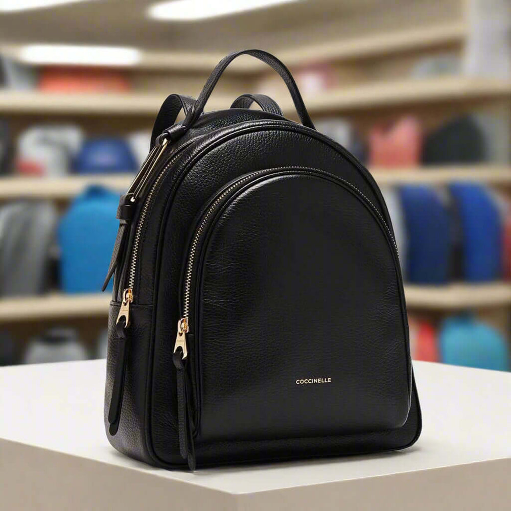 Black backpack with gold zippers on a white background