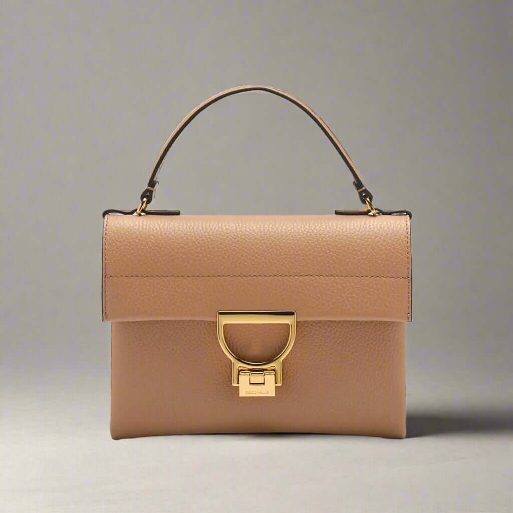 Beige handbag with gold clasp on a white background