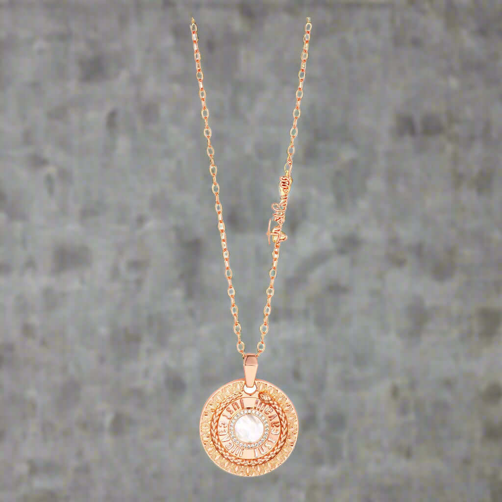 Rose gold necklace with a circular pendant on a white background