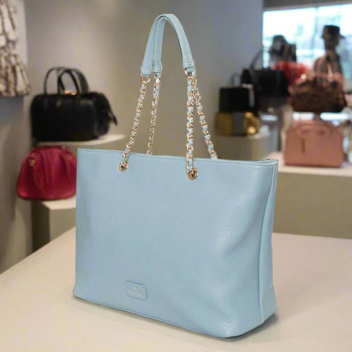 Light blue handbag with chain details on a white background