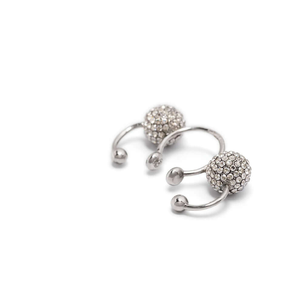 Silver ear cuff with embedded stones on a white background