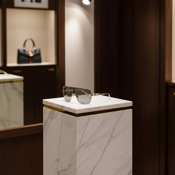 Sunglasses with gold frame and gray lenses on a white background