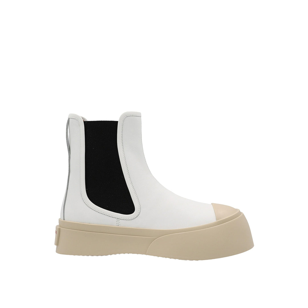 White Chelsea boot with black patch and beige sole on a white background