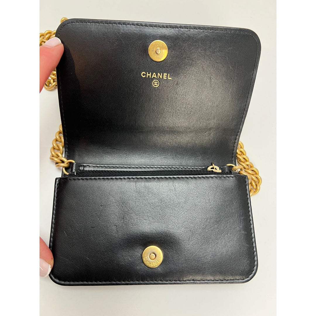 Chanel Caviar Quilted Mini Boy Clutch Wallet on a Chain Black interior showing gold hardware and logo.