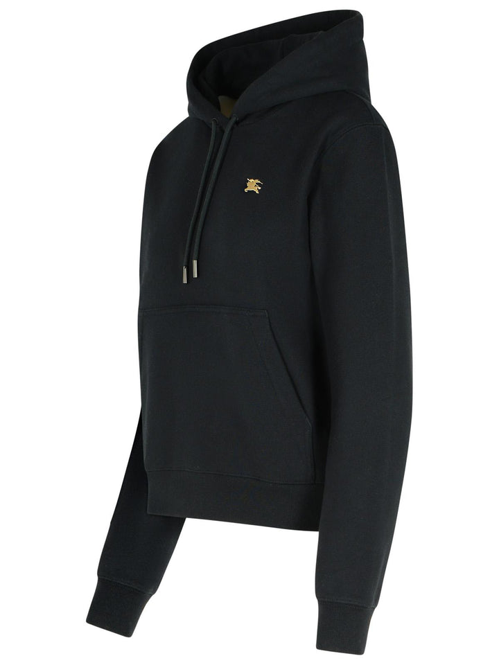 Black hoodie with a gold logo on a white background