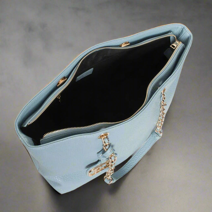 Light blue handbag with gold chain detail on a white background