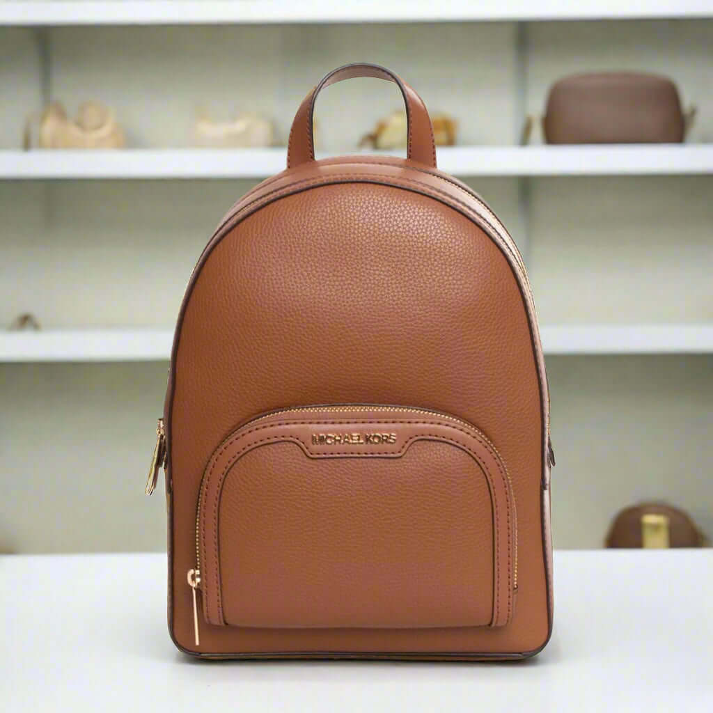 Brown leather backpack with visible brand logo on a white background