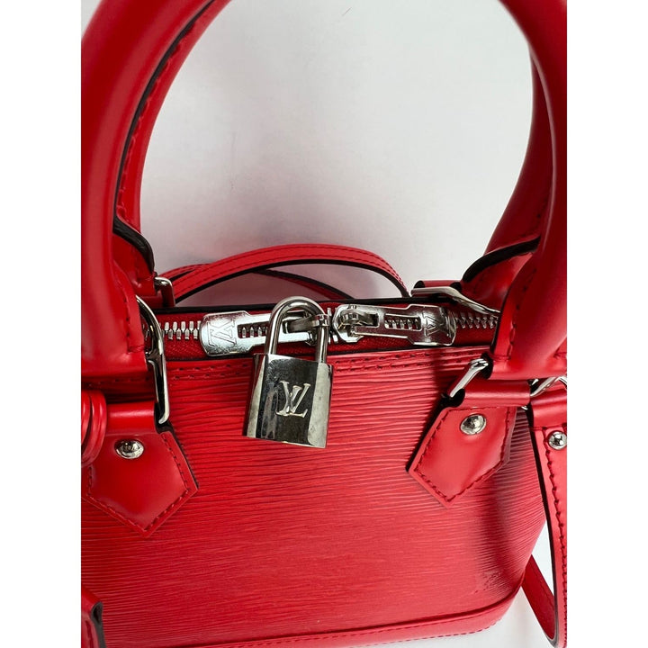 Red handbag with silver lock and hardware on a white background