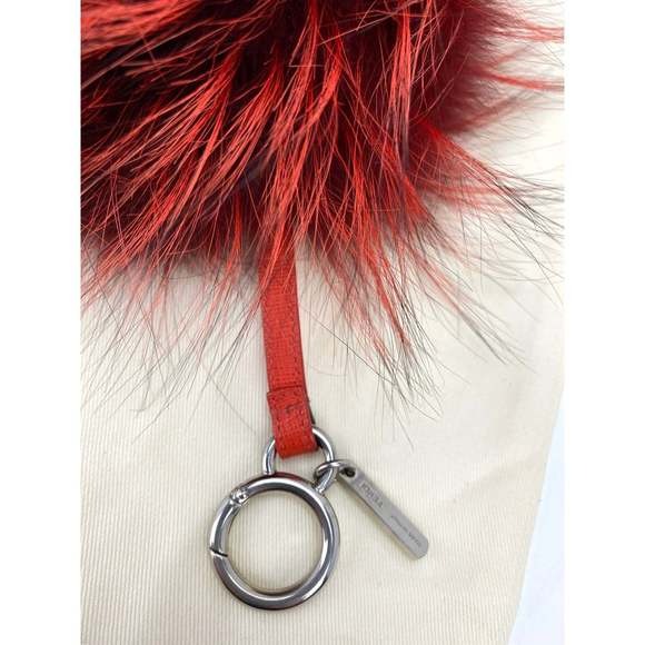 Red feathered keychain with a silver ring on a white background