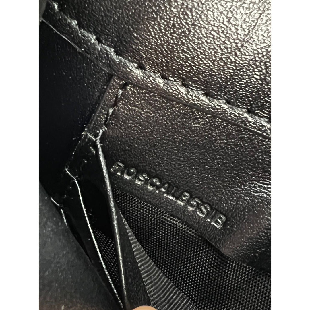 Close-up of a black leather bag with 'Rogacal' branding.