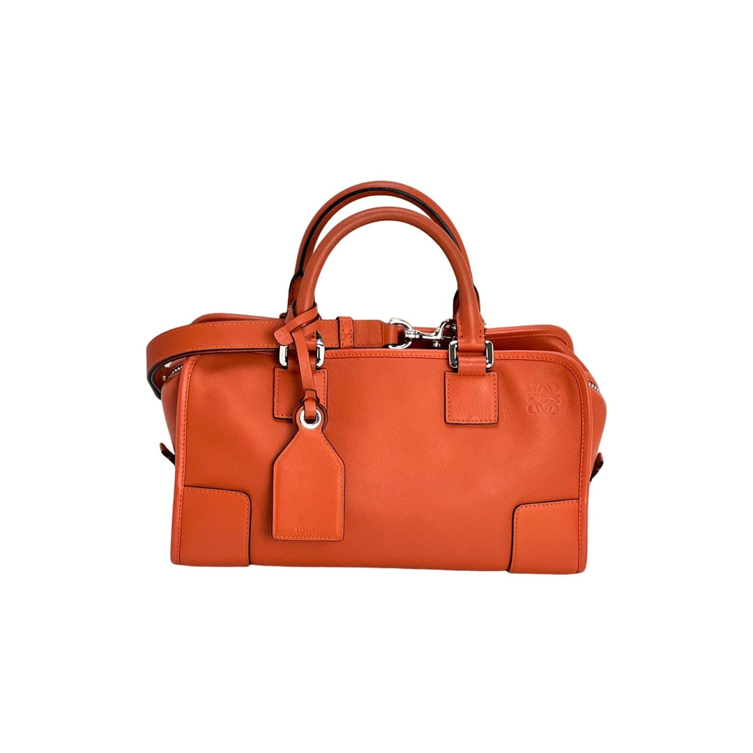 Orange handbag with a tag on a white background
