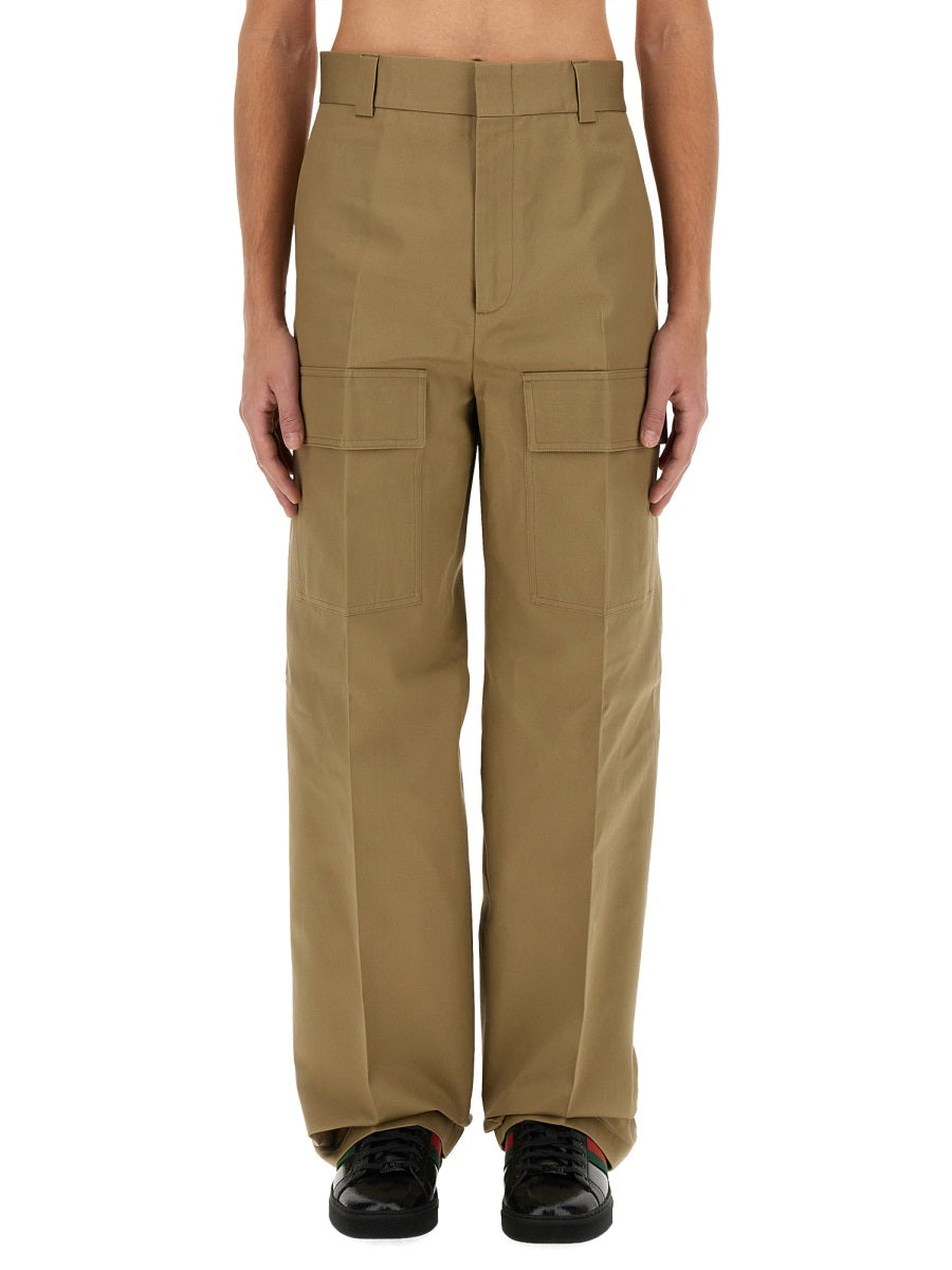 Person wearing beige cargo pants on a white background