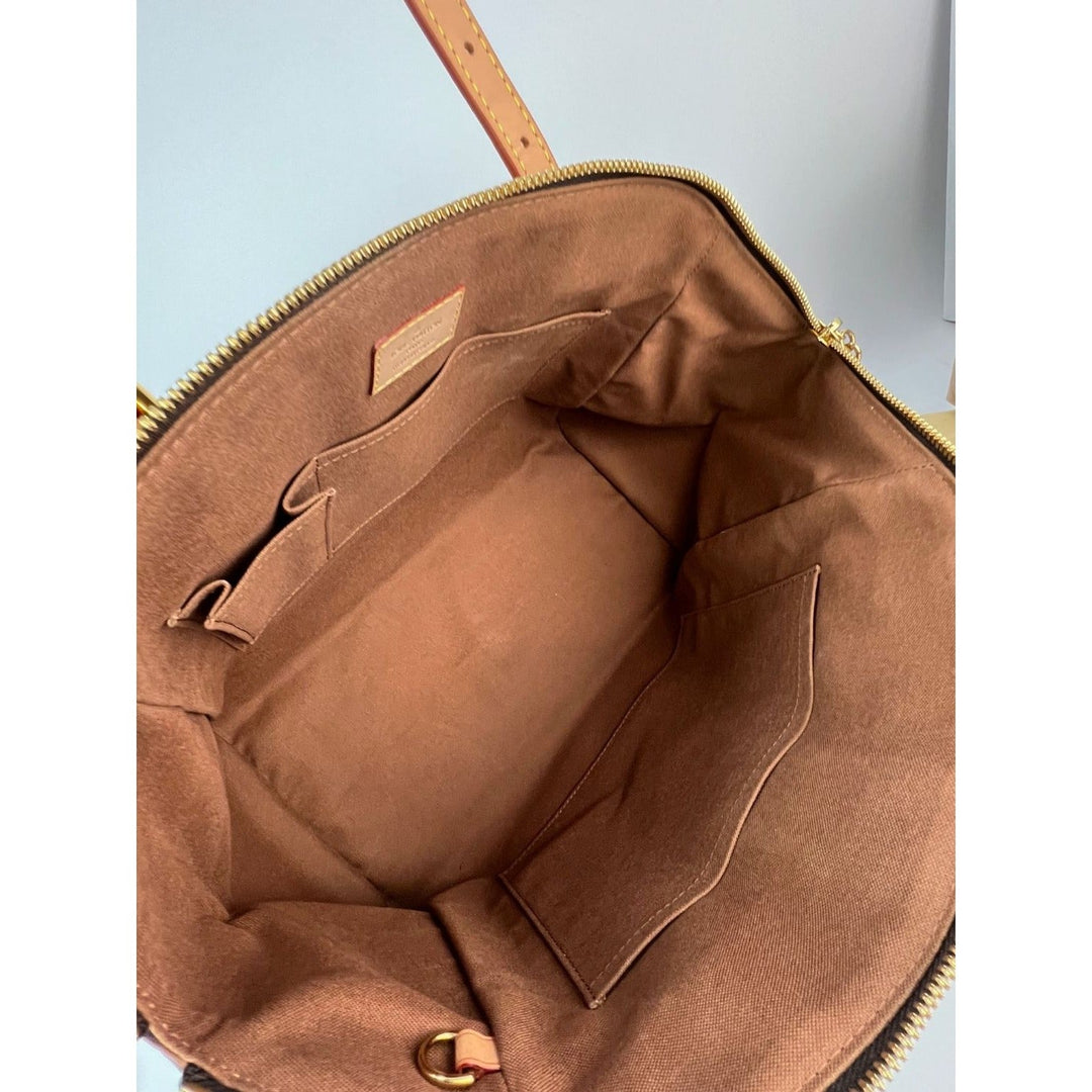 Brown leather bag with gold zipper on a light blue background