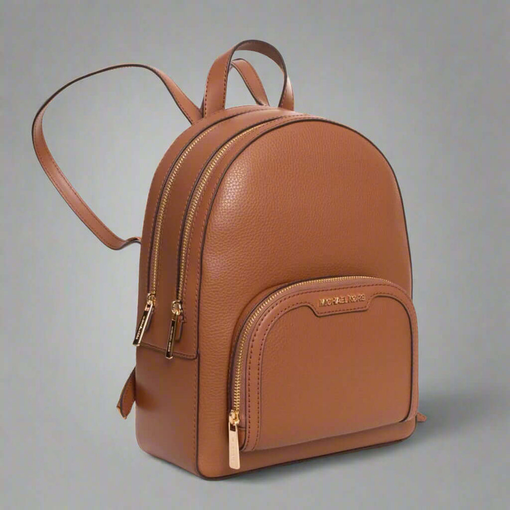 Brown leather backpack with gold zippers on a white background
