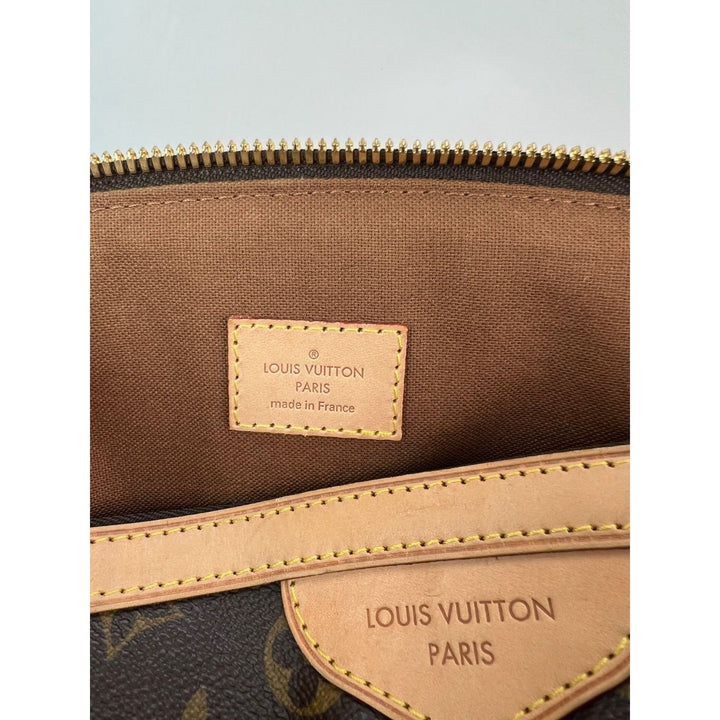Louis Vuitton bag with visible brand logo and text on a light blue background