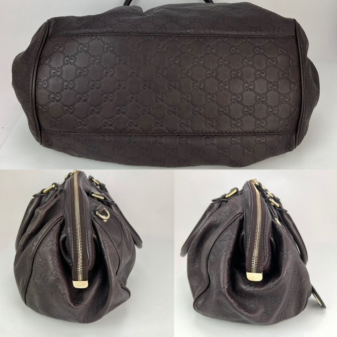 Black textured handbag with gold zipper on a white background