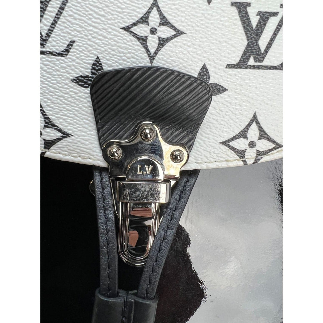 LOUIS VUITTON Hot Springs Backpack White Monogram and Patent Leather hardware close-up with L.V. logo.