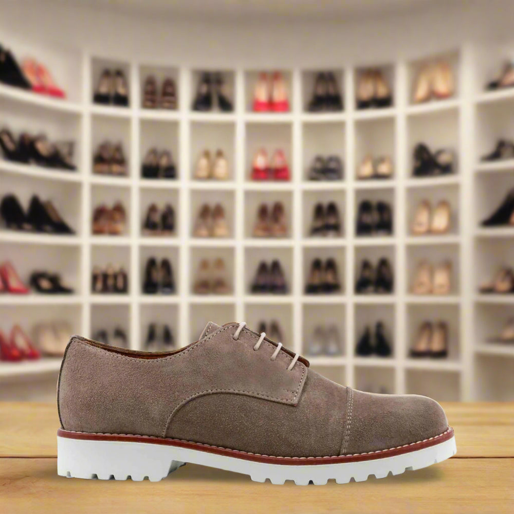 Brown suede shoe with white sole on a white background