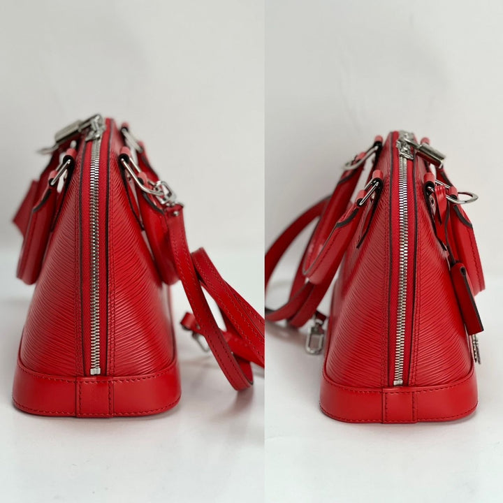 Red handbag with silver zippers on a light gray background