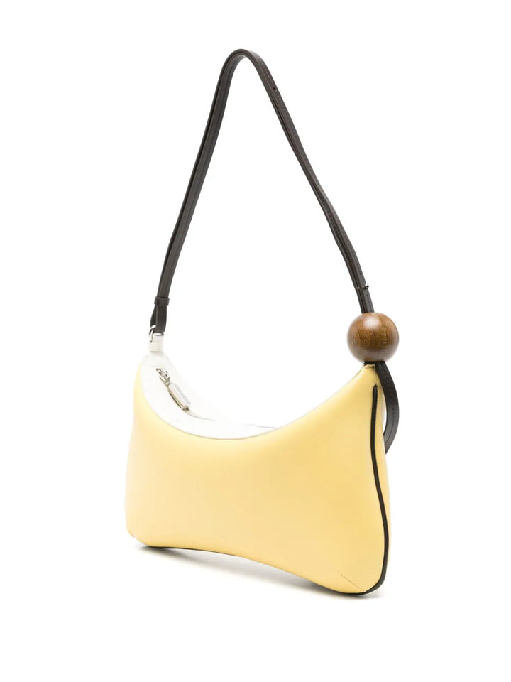 Yellow handbag with a black strap and wooden bead on a white background