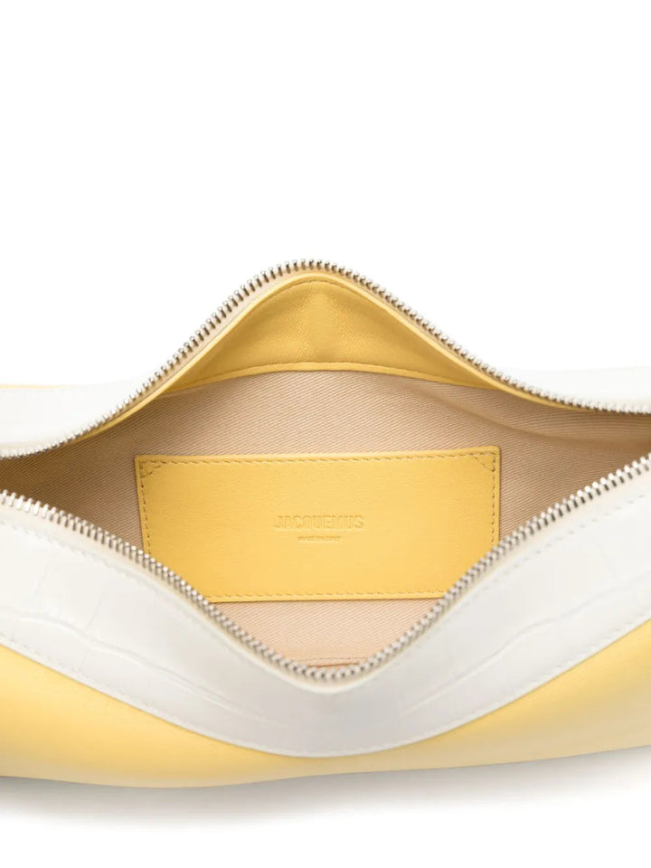Close-up of a yellow and white leather bag with a visible brand label.