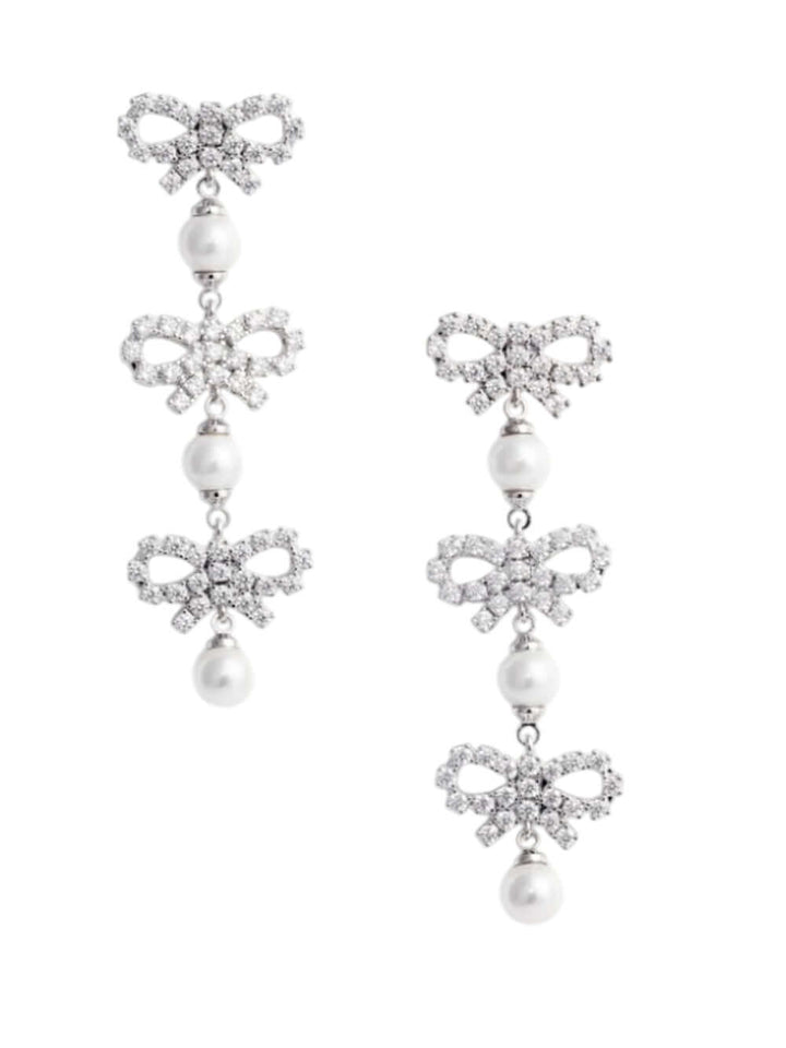 Pair of earrings with bow and pearl designs on a white background
