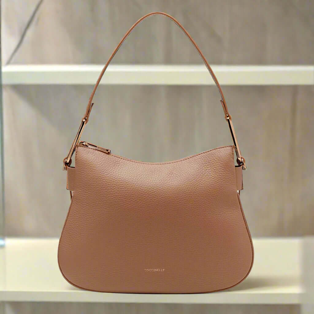 Brown leather handbag with gold hardware on a white background